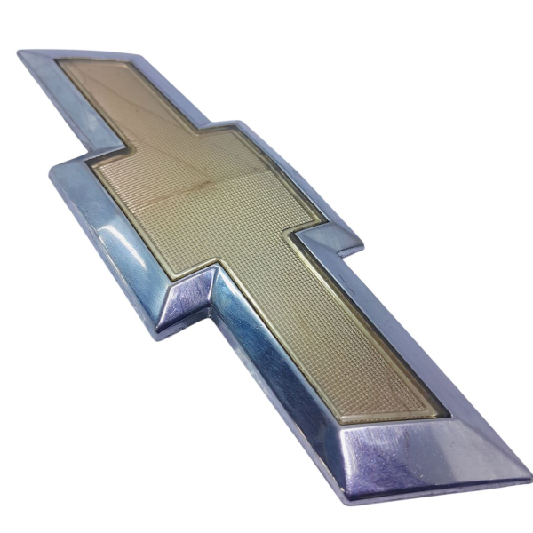 EMBLEMA PARA CHOQUE DIANTEIRO  GM SONIC HB 1.6 2013 200858